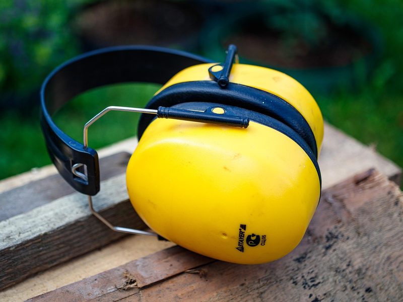 Yellow protective ear muffs resting on wood