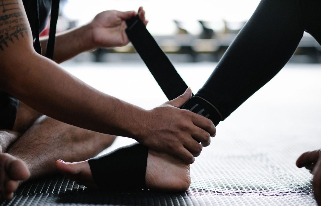 Ankle being wrapped for support in a gym