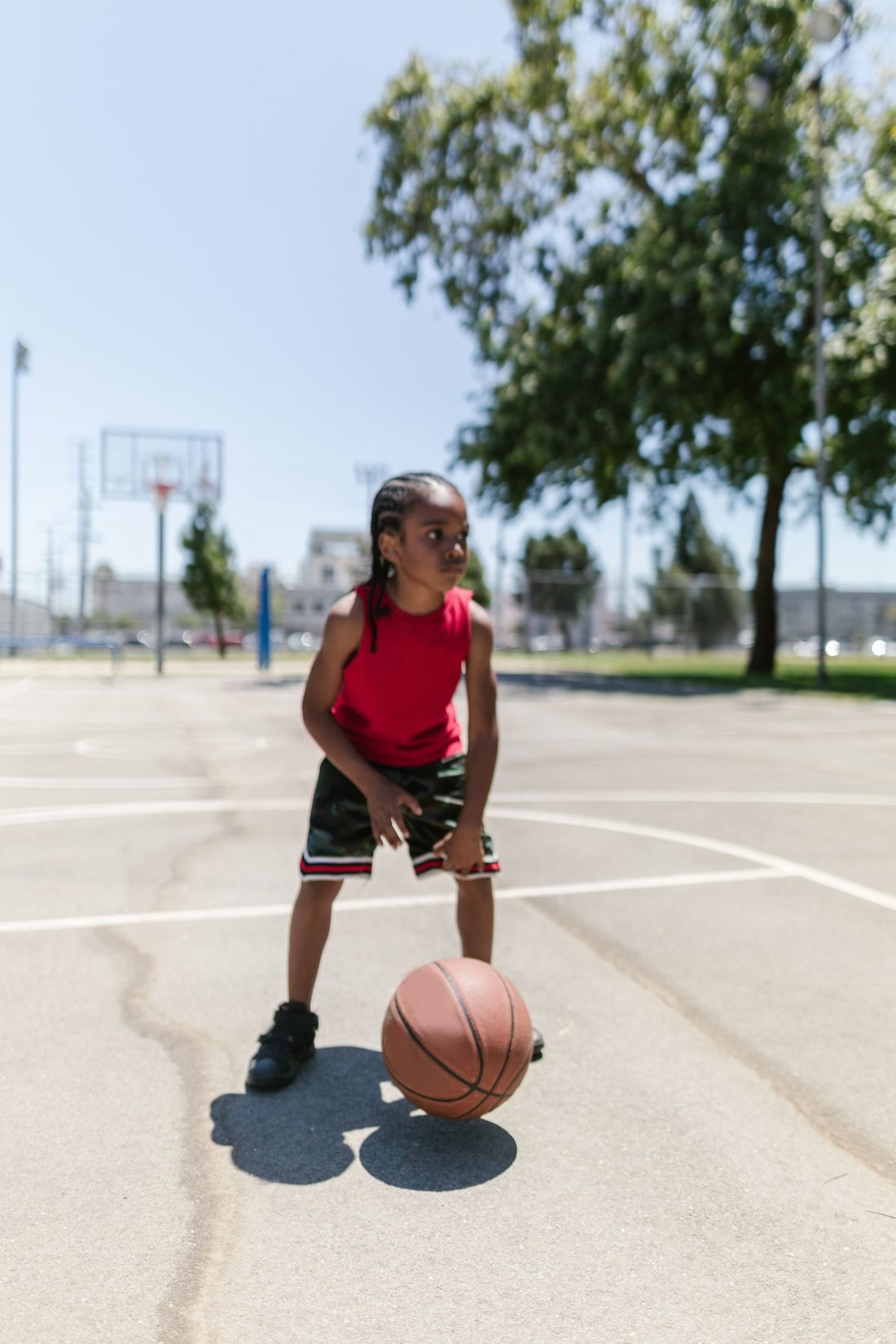 Child dribbling a basketball on an outdoor court