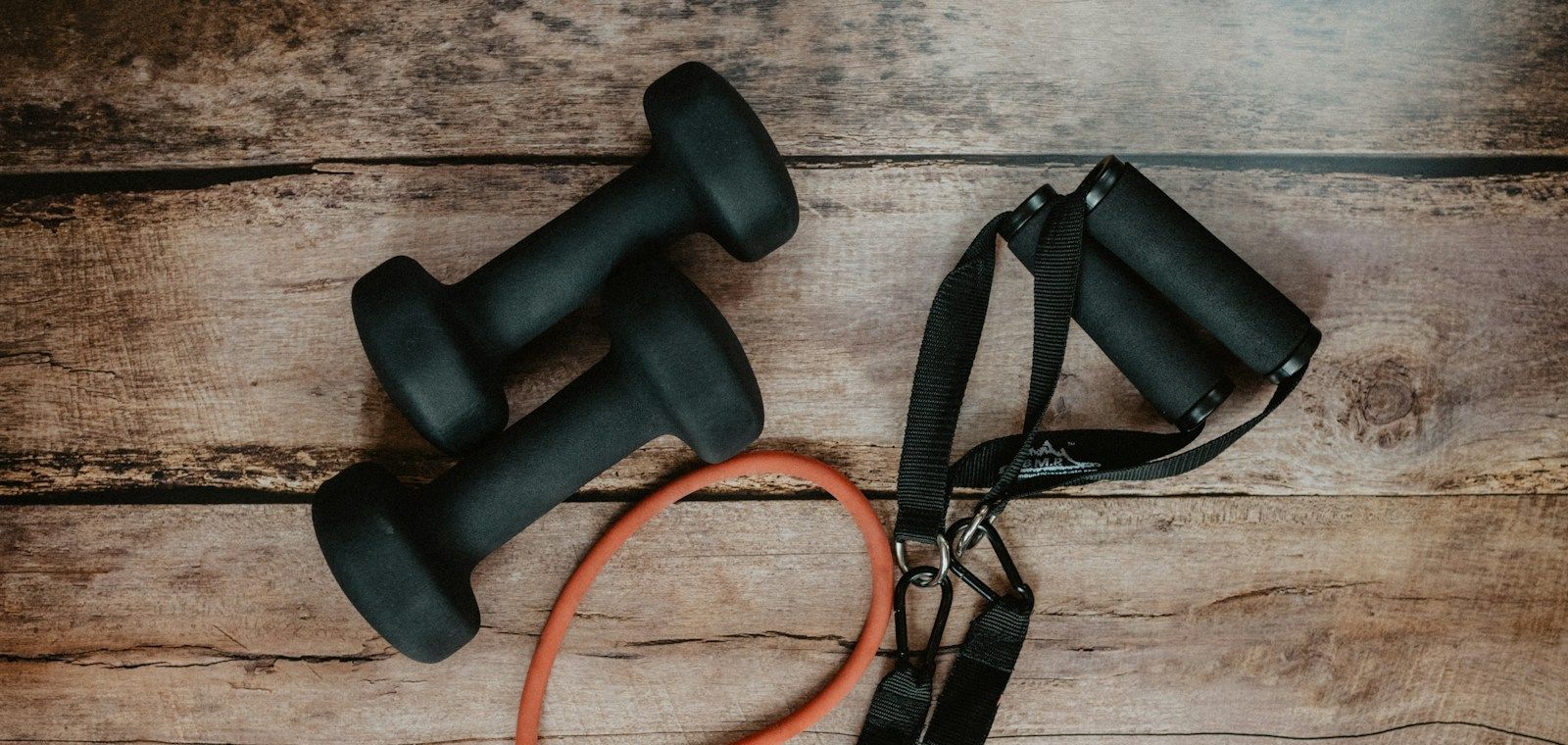 Dumbbells and resistance band on a wooden floor