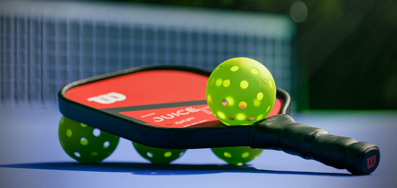 Pickleball paddle and balls on an outdoor court