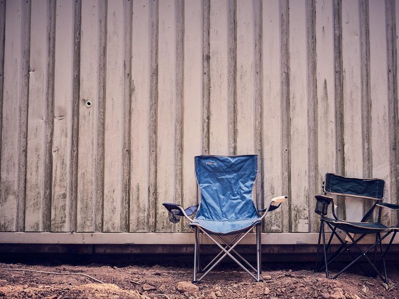 Two folding camp chairs set up outdoors