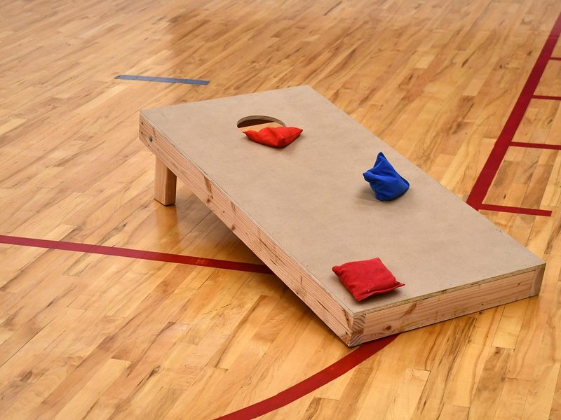 A wooden cornhole board with bean bags